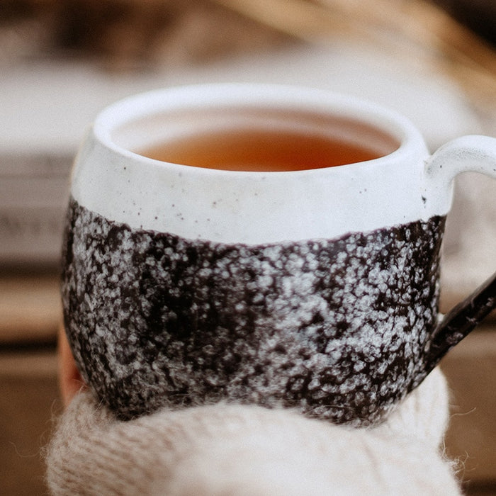 Eine Tasse Tee wird in der Hand gehalten 