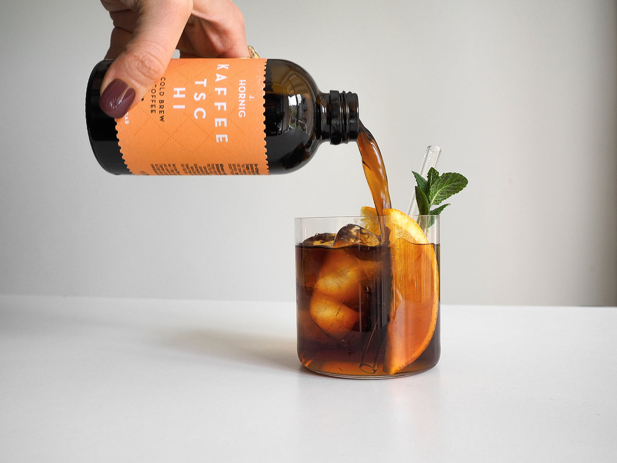 Kaffeetschi wird in ein Glas gegossen, um einen Aperol Coffee Spritz zumachen.