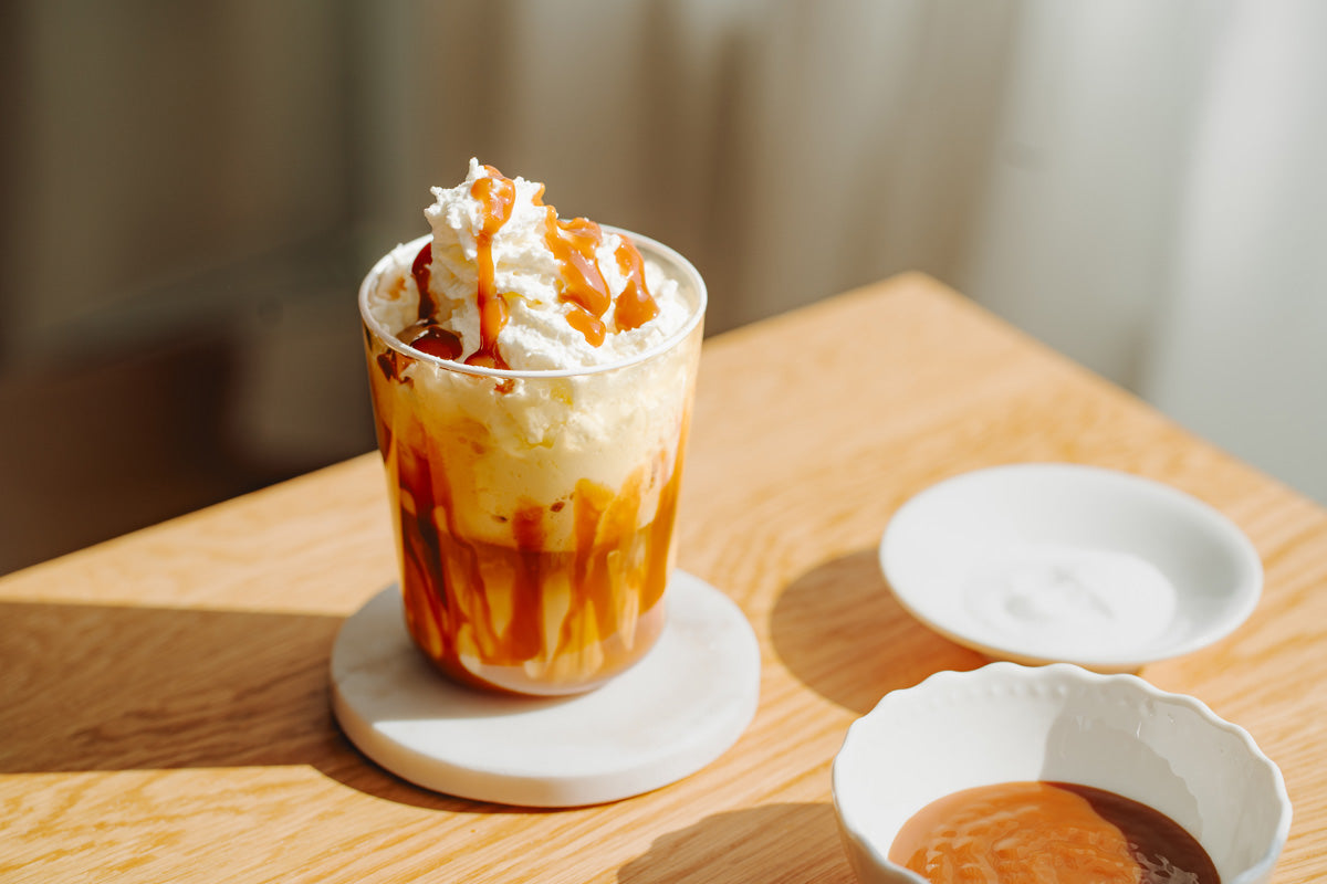 Salted Caramel Latte in einem Glas steht auf einem Tisch