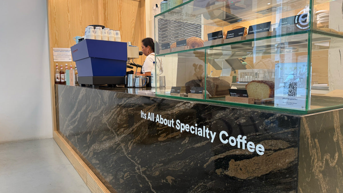 Theke im East Crema Coffee Café mit Gebäck in der Auslage und einer großen blauen Kaffeemaschine.