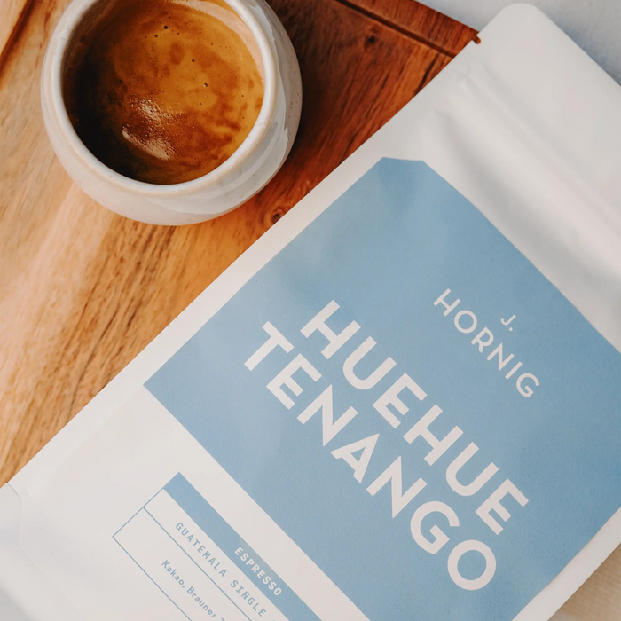 Schrägansicht von J. Hornig Guatemala Huehuetenango Spezialitätenkaffee auf hellem Holzuntergrund.