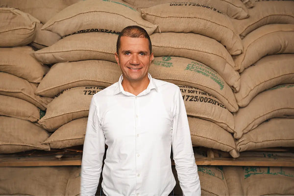Ein Portrait eines Mannes vor Kaffeesäcken.